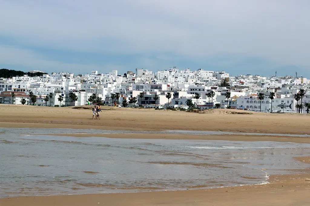 Playa de Conil al atardecer con su característico paseo marítimo y arena dorada